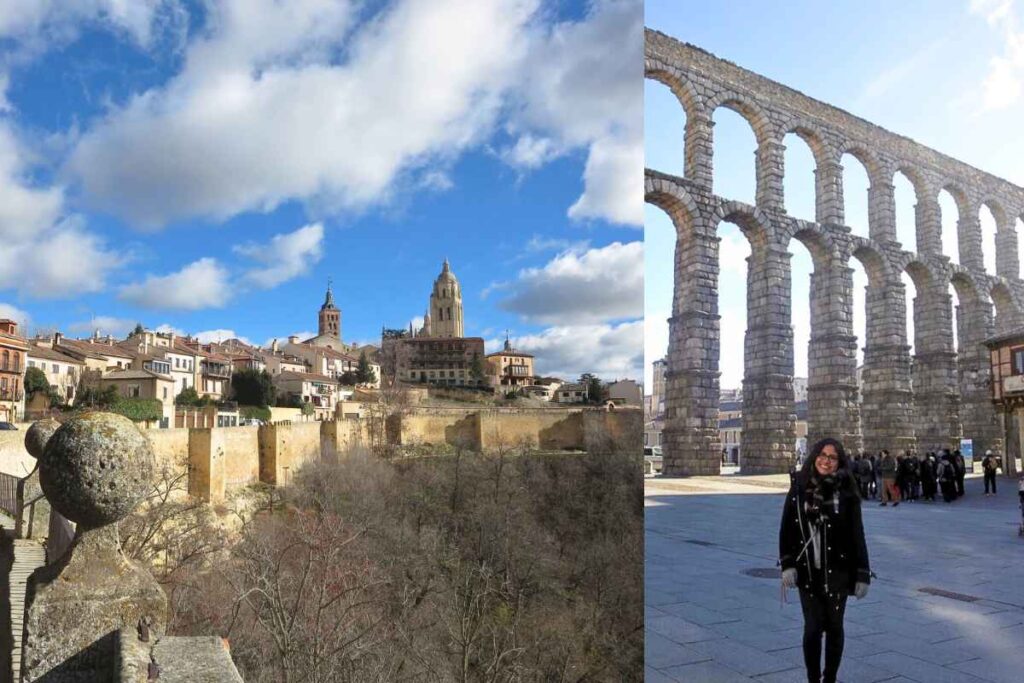 A scenic view of Segovia’s old town, featuring a hilltop cathedral and medieval walls, bathed in sunlight. On the right, a woman dressed in black poses in front of the famous Segovia Roman aqueduct, a towering stone structure. Best day trips from Madrid.