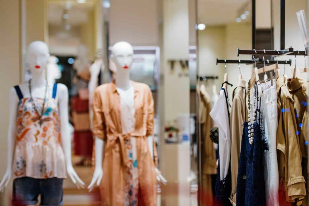 Mannequins in a stylish clothing store, displaying a variety of fashionable outfits including dresses and casual wear.