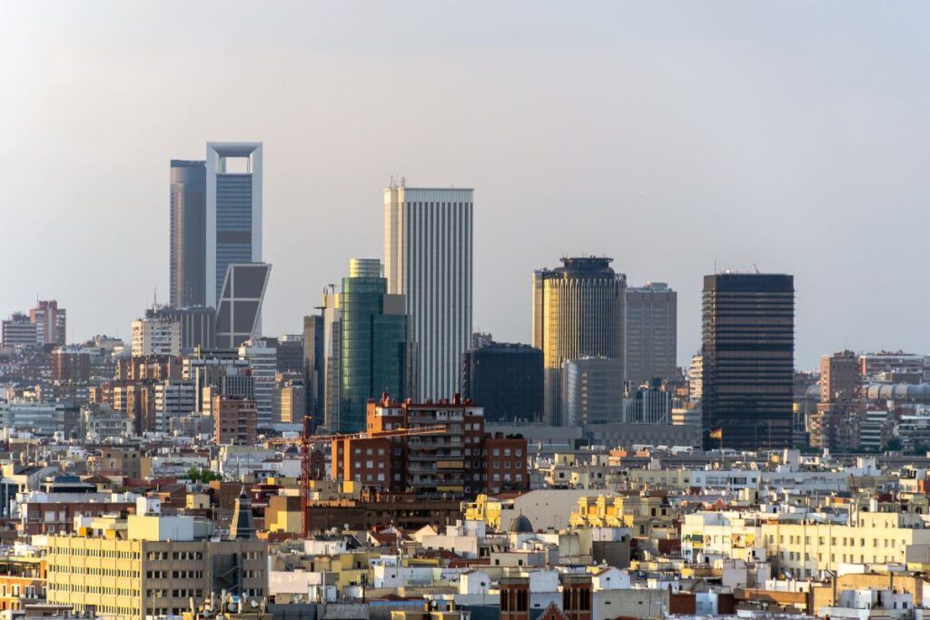 A panoramic view of Madrid’s modern skyline, featuring the Four Towers Business Area. This area offers luxury hotels and business-friendly accommodations. Where to stay in Madrid for the first time.