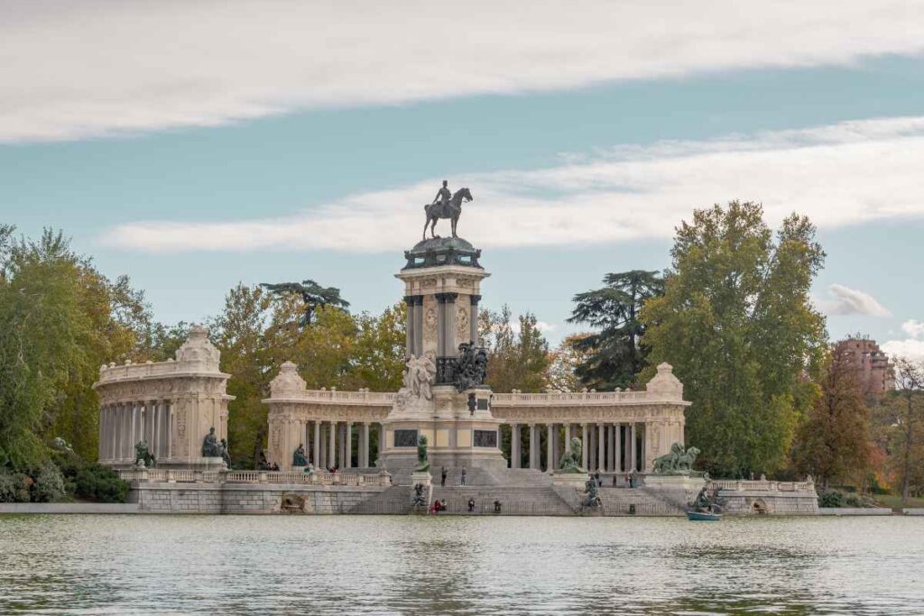 The Monument to Alfonso XII in Retiro Park, surrounded by a serene lake. Staying near Retiro Park is a fantastic option when considering where to stay in Madrid for the first time.